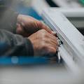 Man's hands unlocking a briefcase.