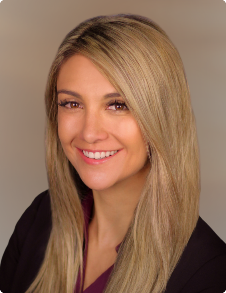 Headshot of woman in front of white background, wearing black dress shirt.
