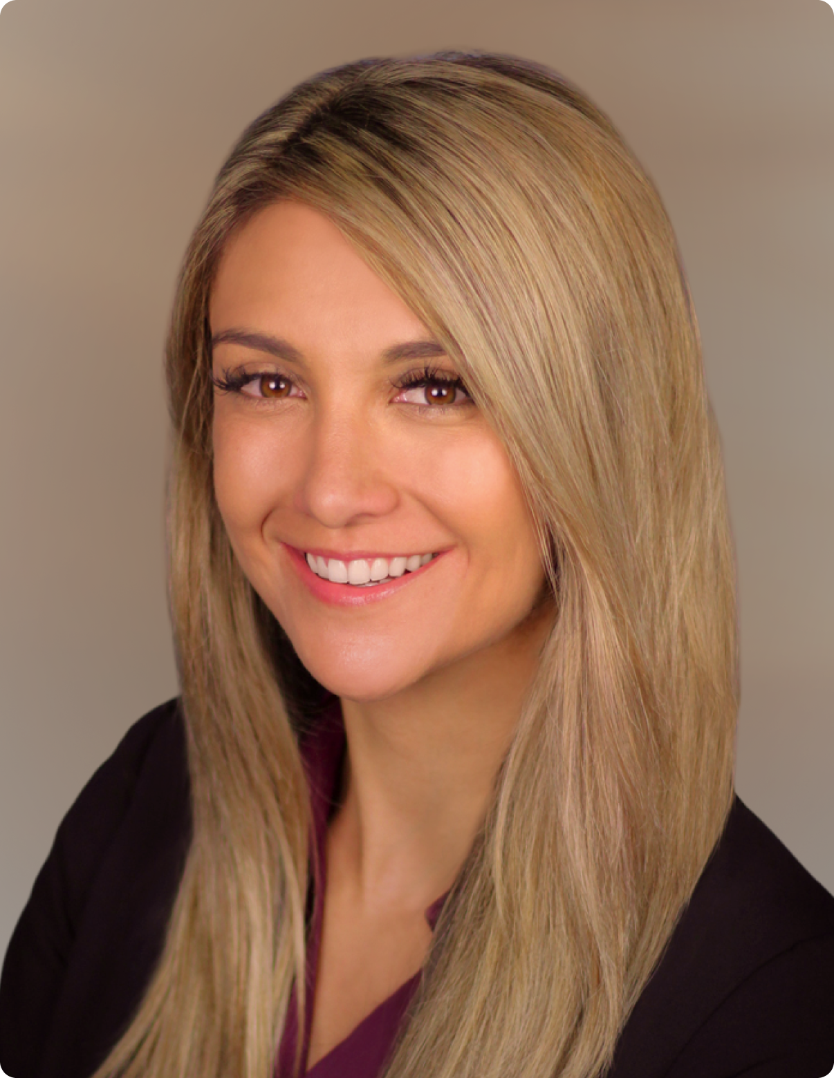 Headshot of woman in front of white background, wearing black dress shirt.