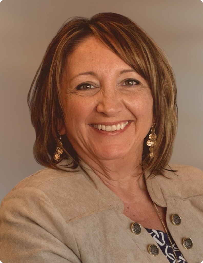 Headshot of woman in front of white background, wearing blazer.