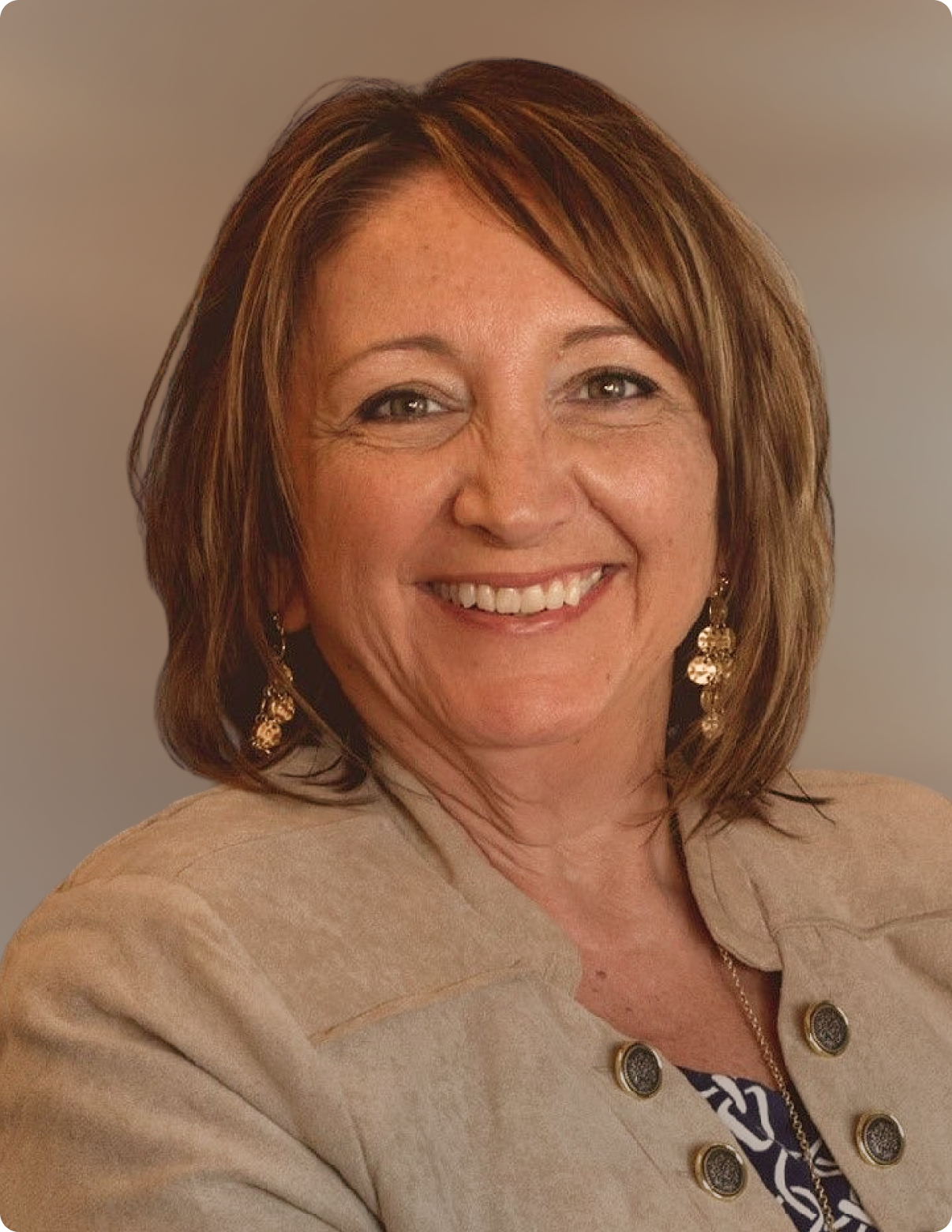 Headshot of woman in front of white background, wearing blazer.