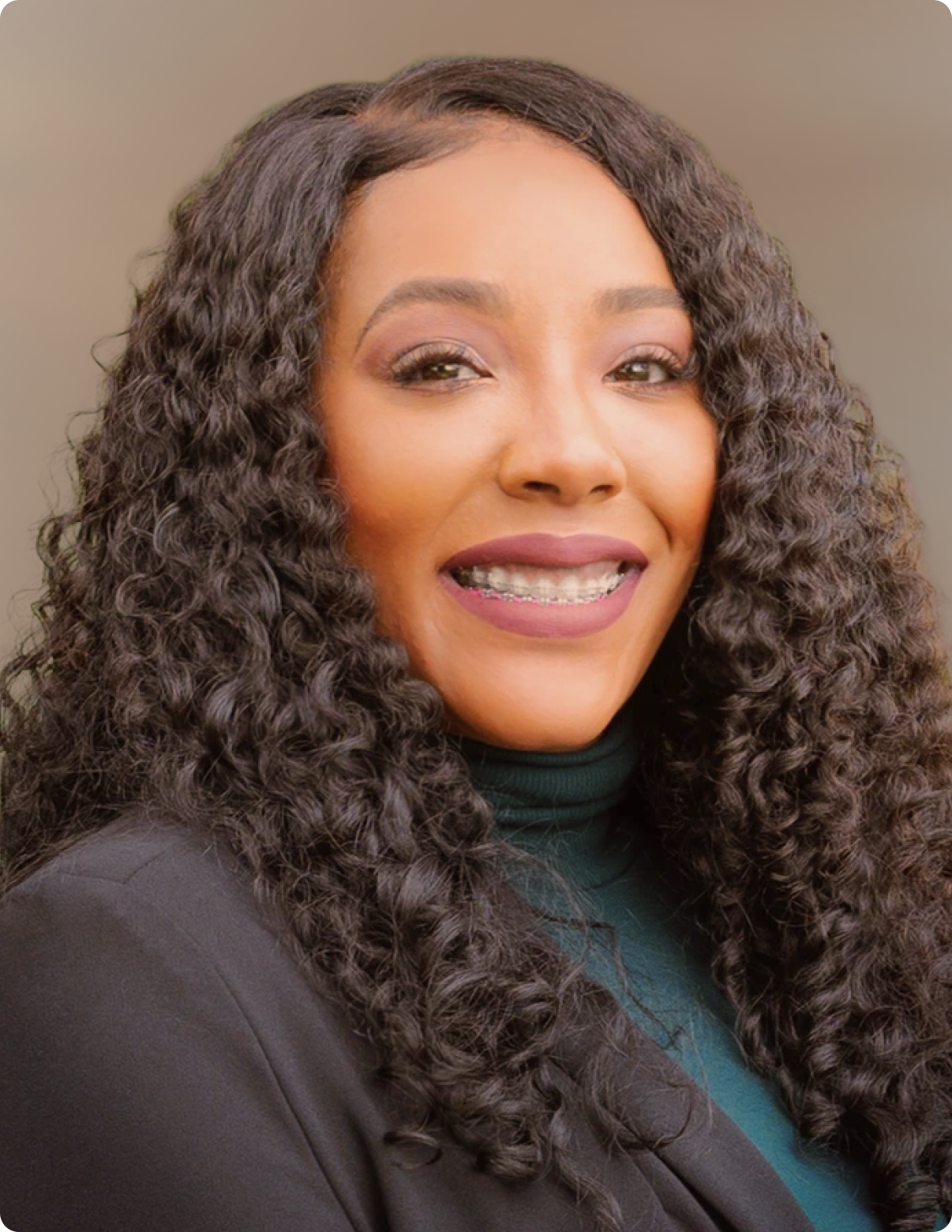 Headshot of woman in front of white background, wearing black blazer.