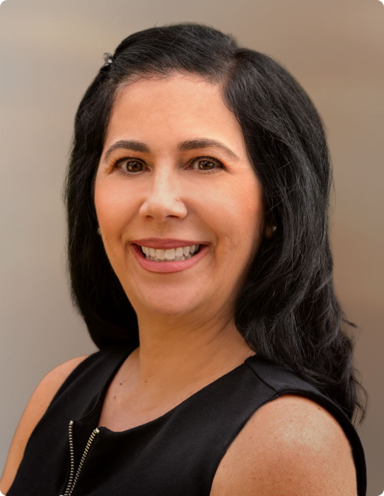 Headshot of woman in front of white background, wearing black dress shirt.