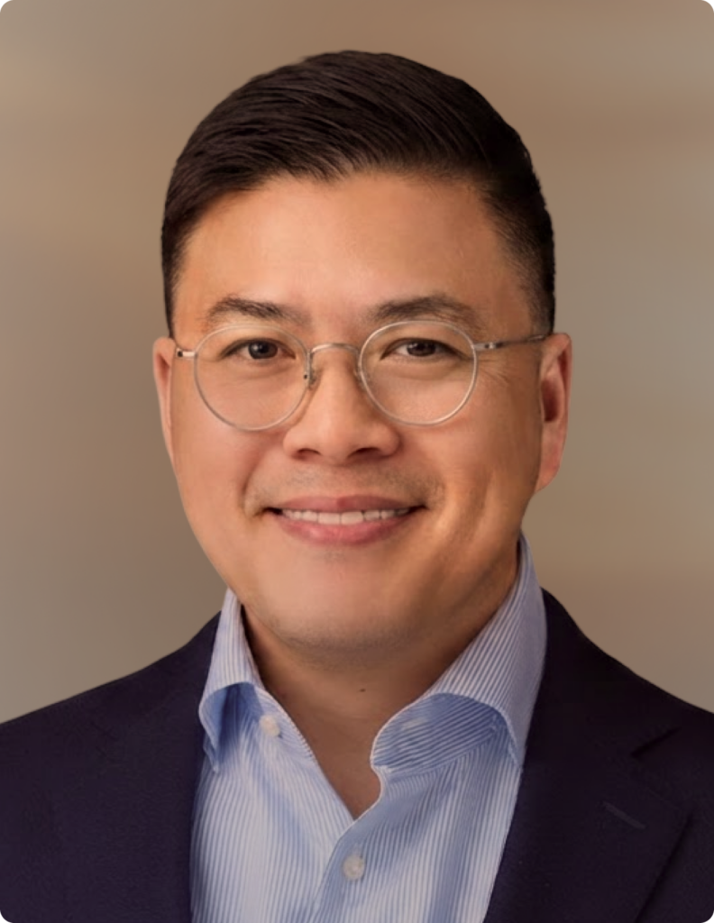 Headshot of man in front of white background.