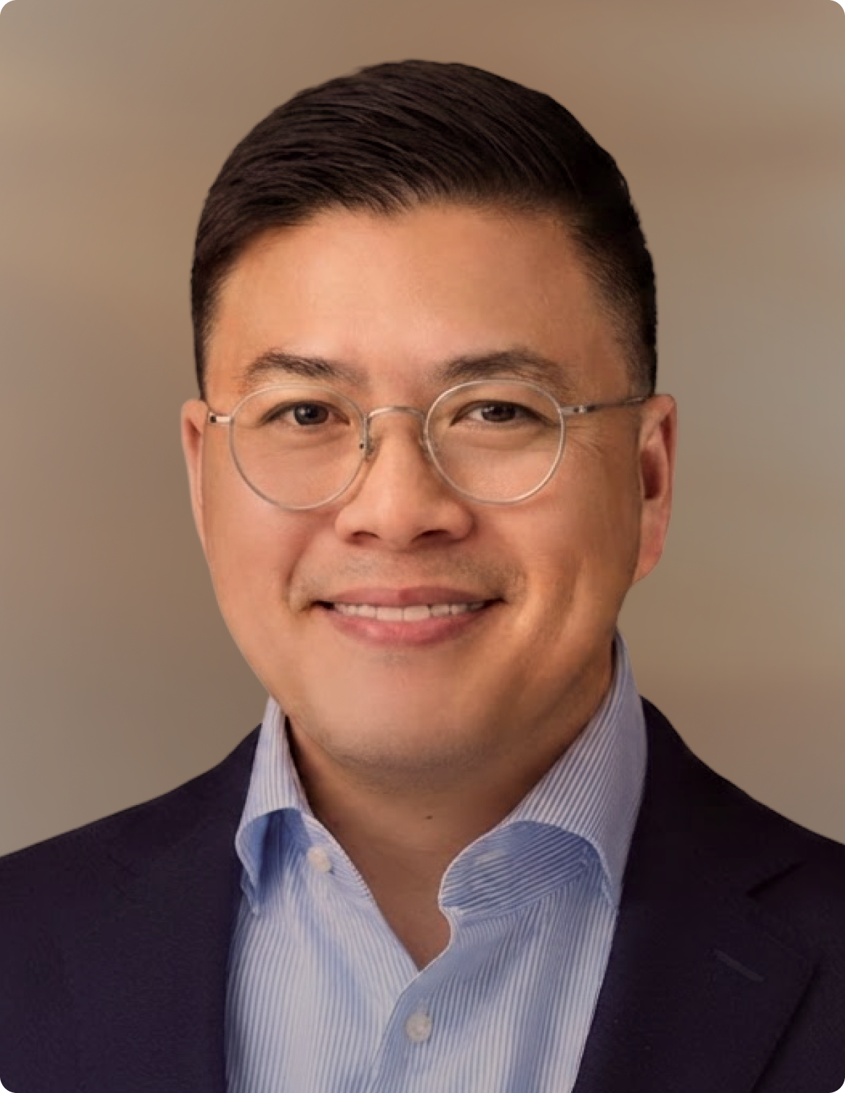 Headshot of man in front of white background.