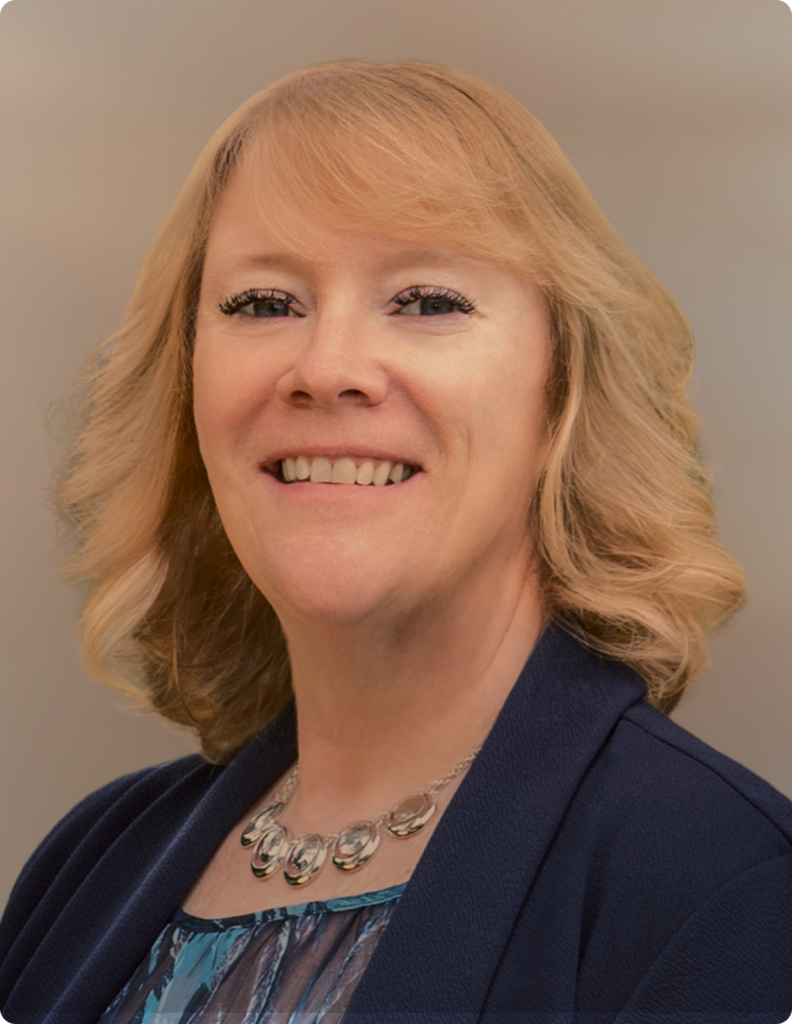 Headshot of woman in front of white background, wearing blue blazer.